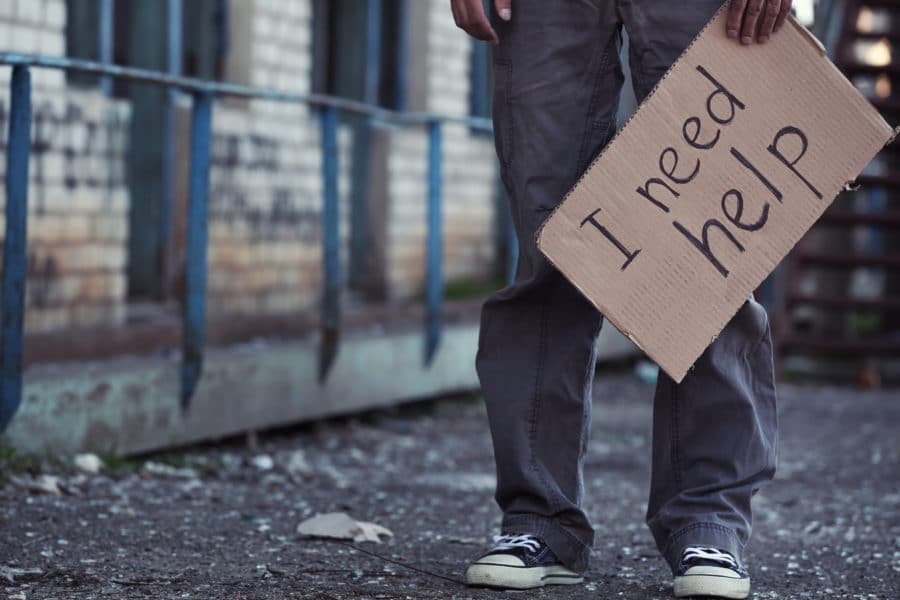 Poor Man Begging For Help On The Street representing medical plans for those who qualify for Medicare and Medicaid